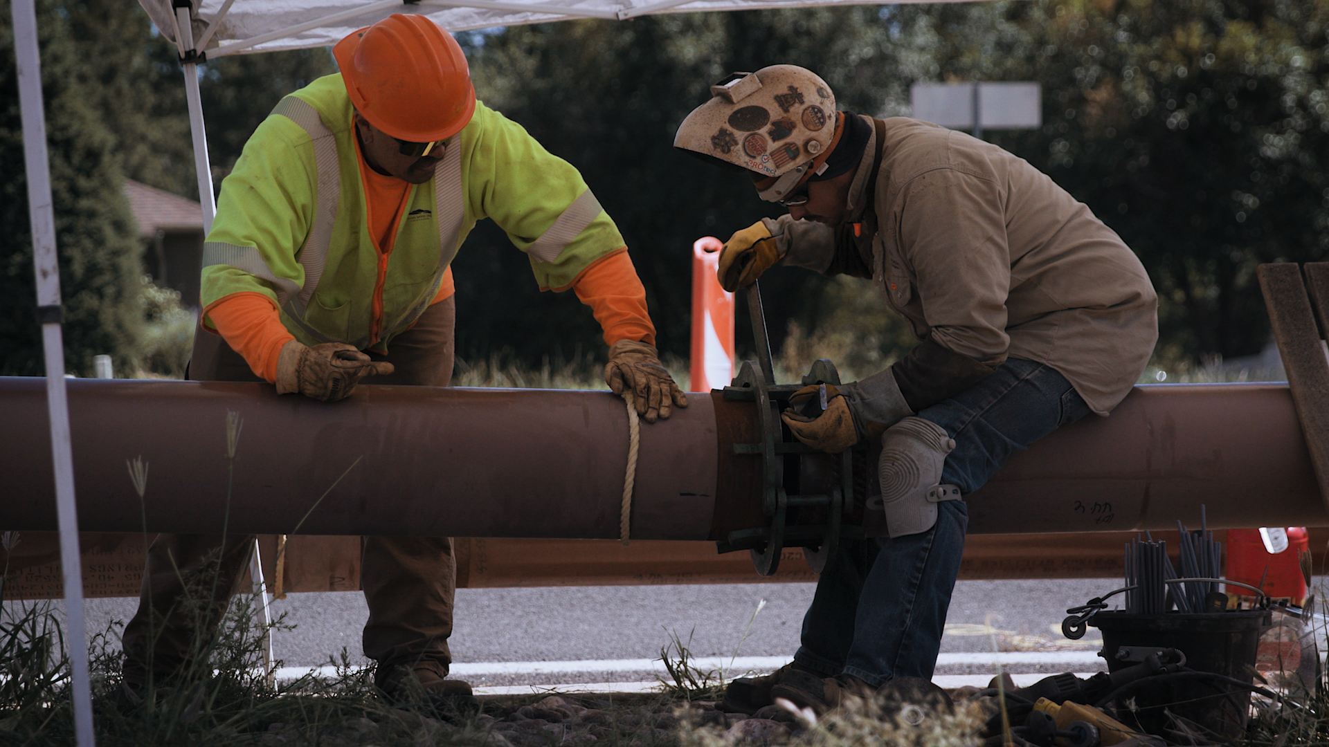 two workers repair a wastewater pipe