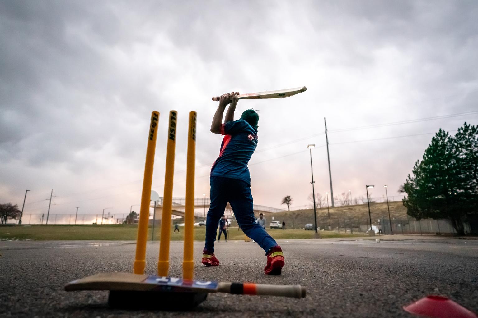 Cricket player swings a bat