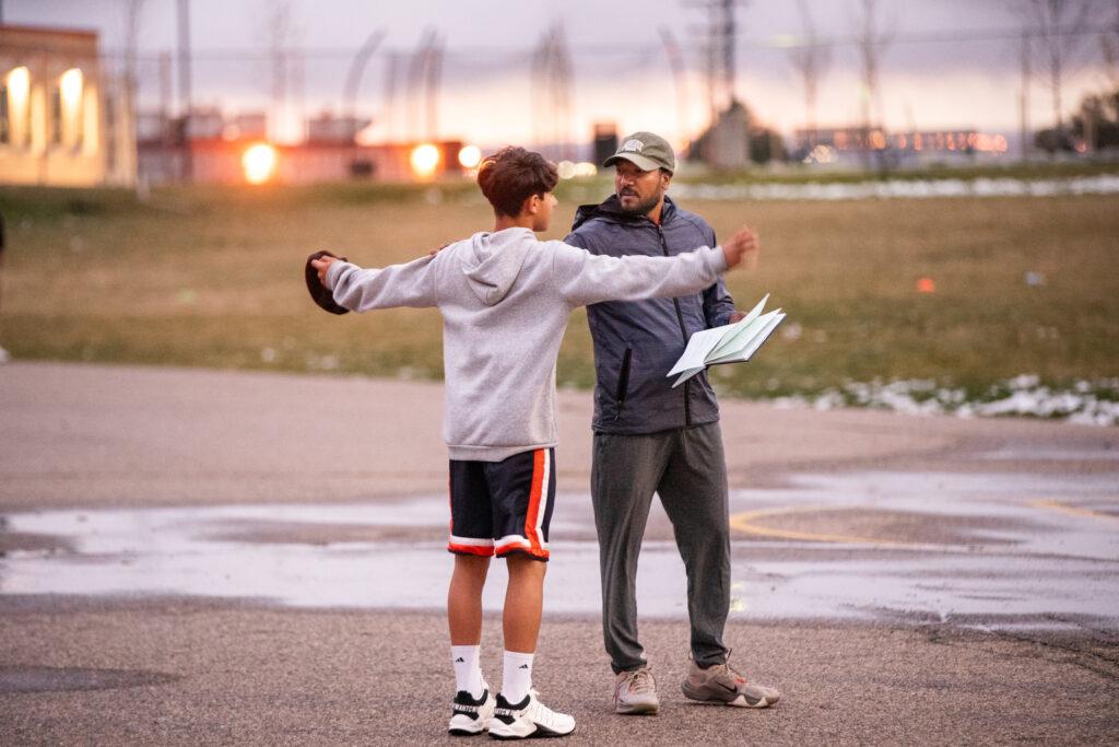 Cricket play waves arms talking to coach