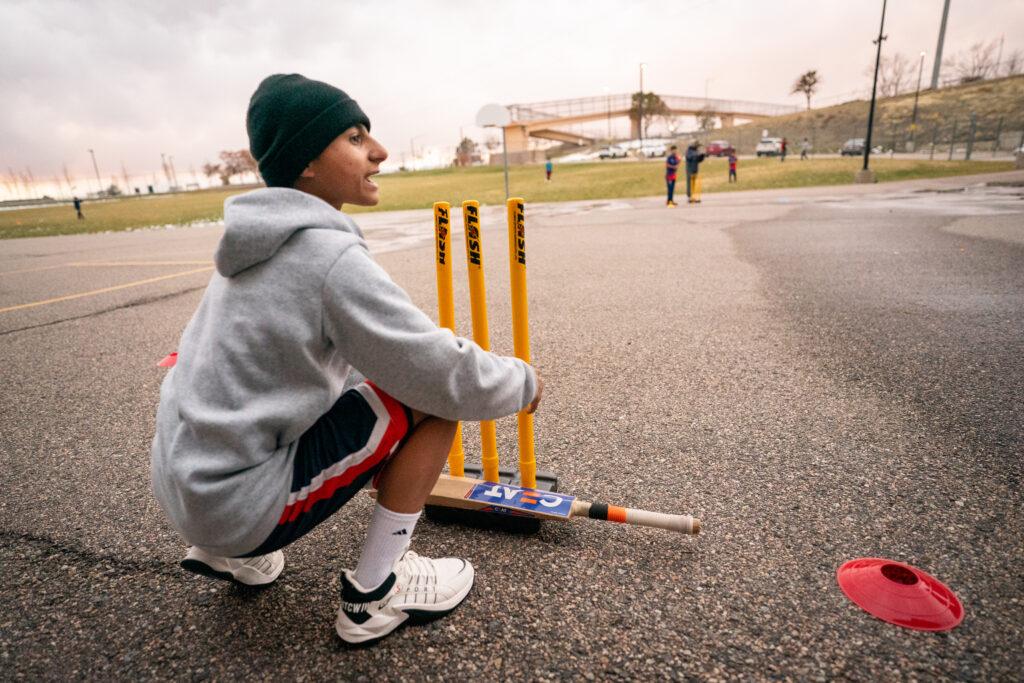 Cricket player arranges equipment on the playground