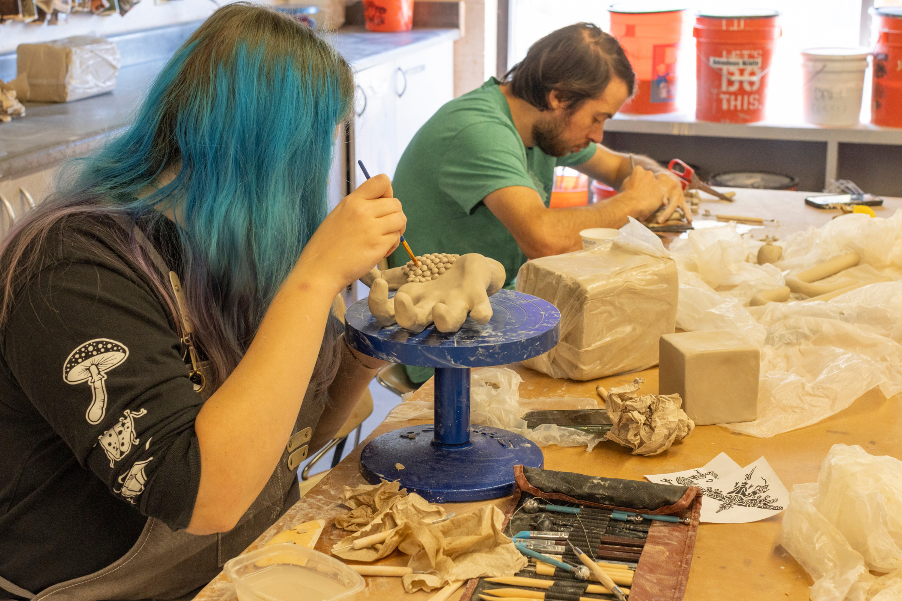 Two students working on their tactile projects in the ceramics studio