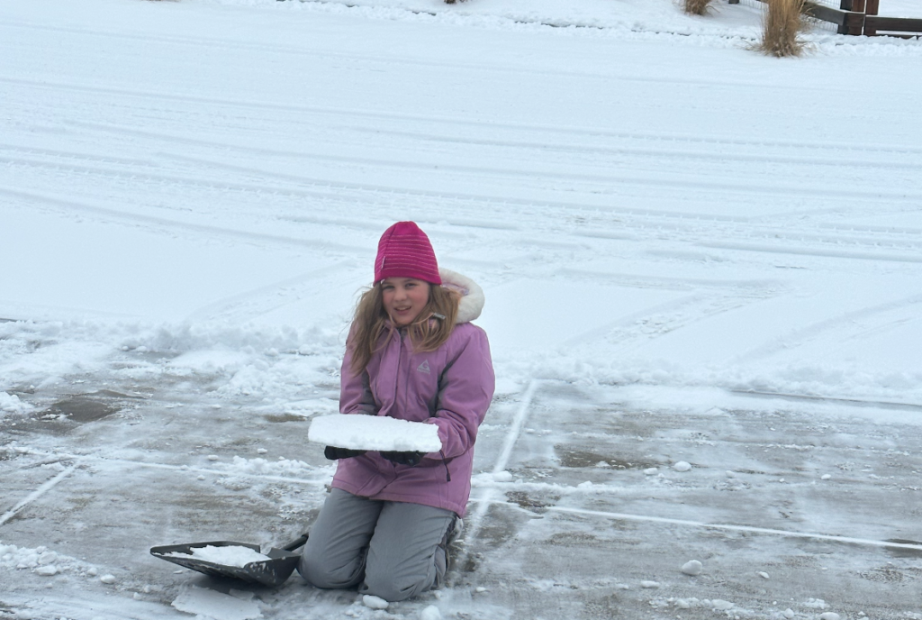 Emily with a slab of snow and purple coat.