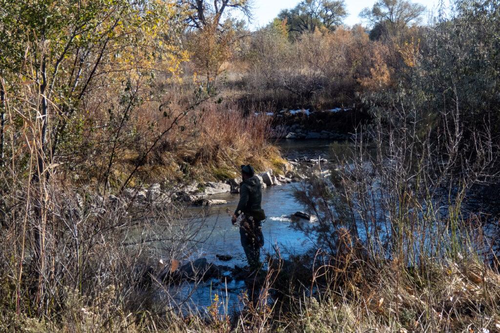 a person fishes in a large creek