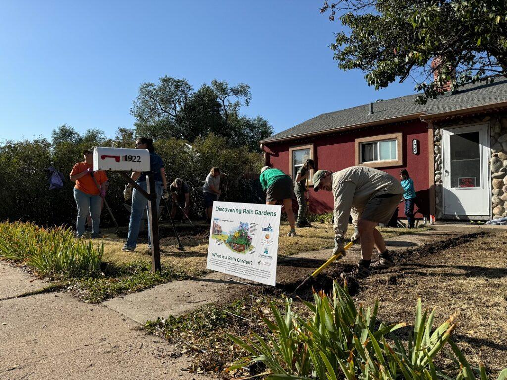 People doing yard work in front of a home.