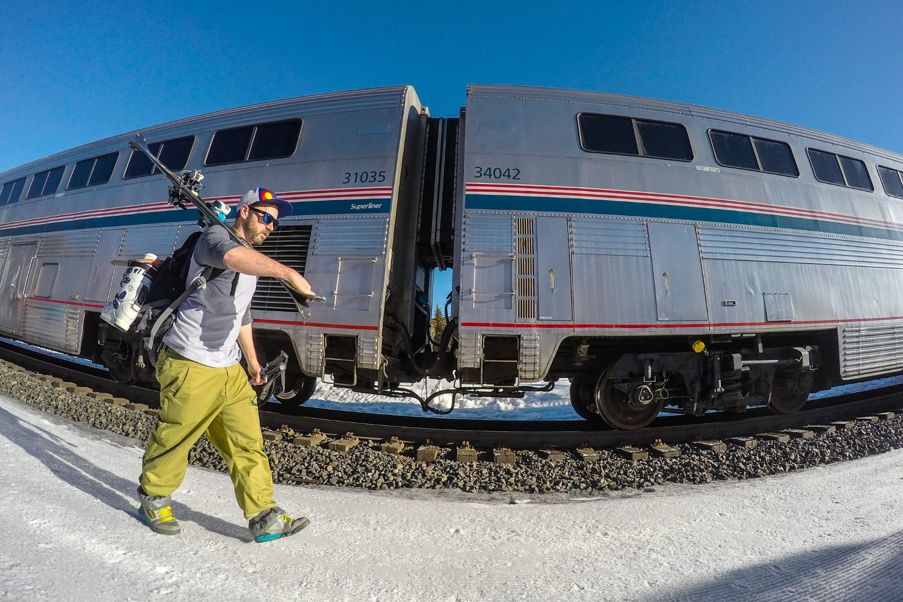 A skier carries their equipment to board the Winter Park Express ski trai