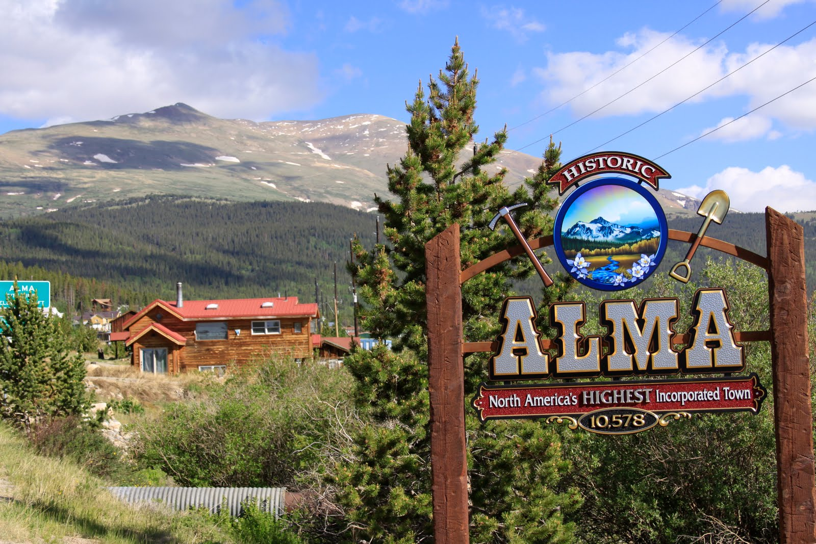 wooden sign with silver letters that say Alma North America's Highest Incorporated Town.