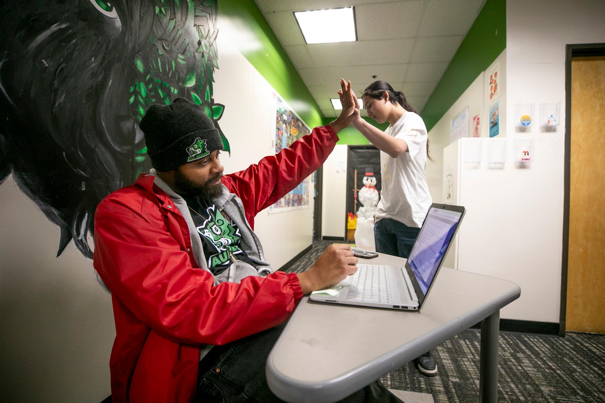 A principal high-fives a student.