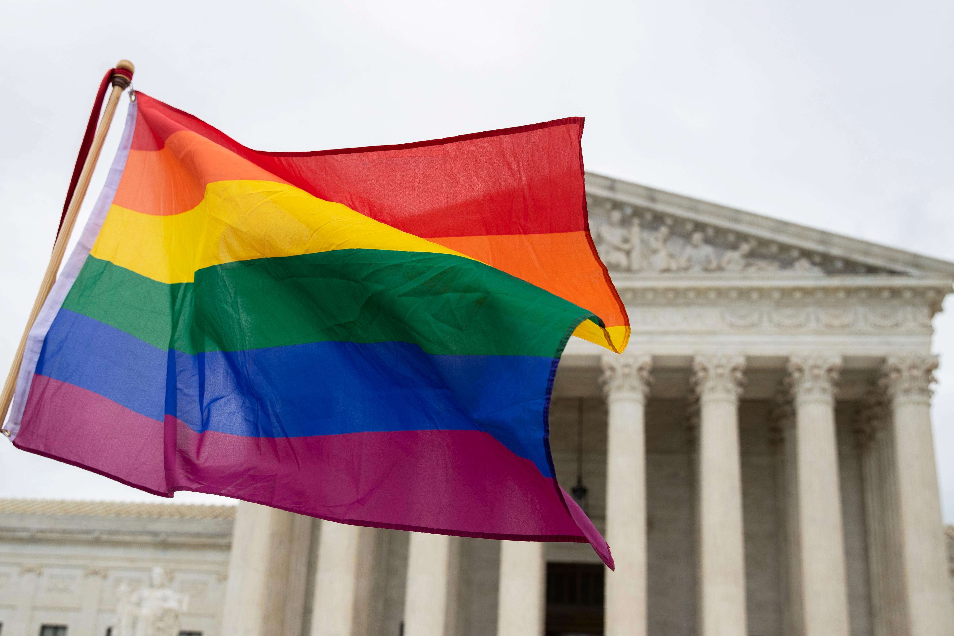 Supporters wave a pride flag in front of the U.S. Supreme Cour