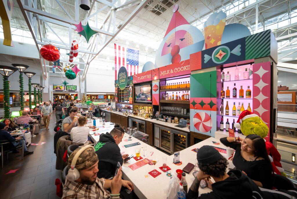 Picture shows people eating at a counter in Santa's Layover Lounge at DIA.