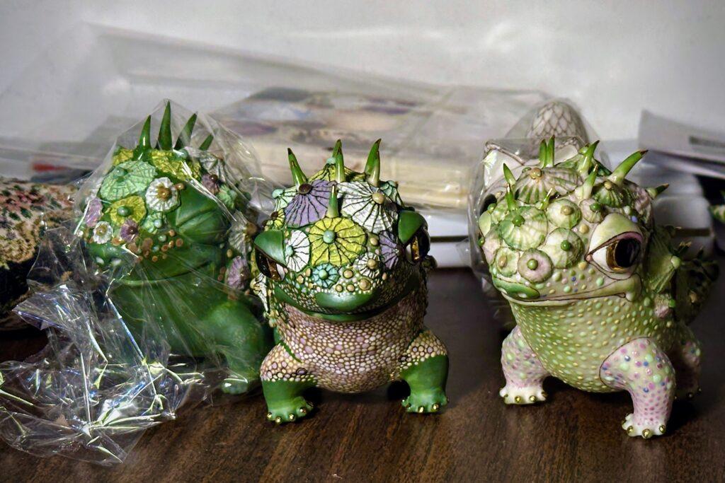 A close up of a trio of small porcelain dragon figurines by artists Slava Leontyev and Anya Stasenko, sitting on a table