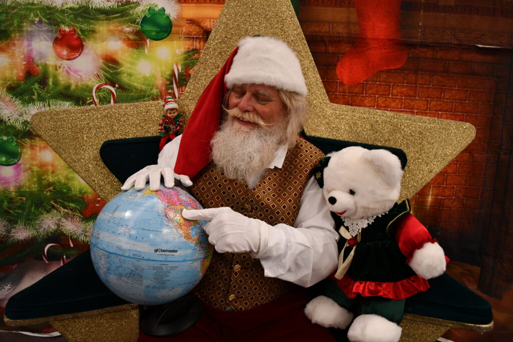 Santa Clause shows his route on a globe