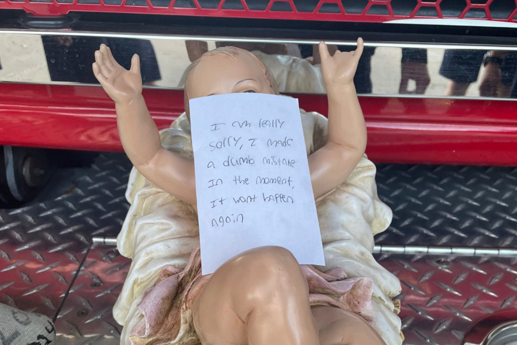 A stolen baby Jesus figurine with a handwritten apology note on top of it