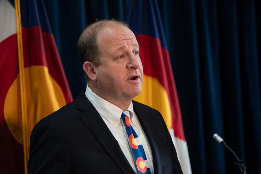 Jared Polis speaks with reporters after the State of the State address.