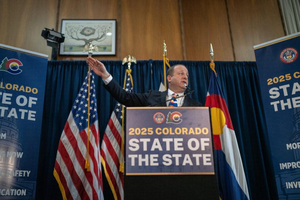 Jared Polis speaks with reporters after the State of the State address.