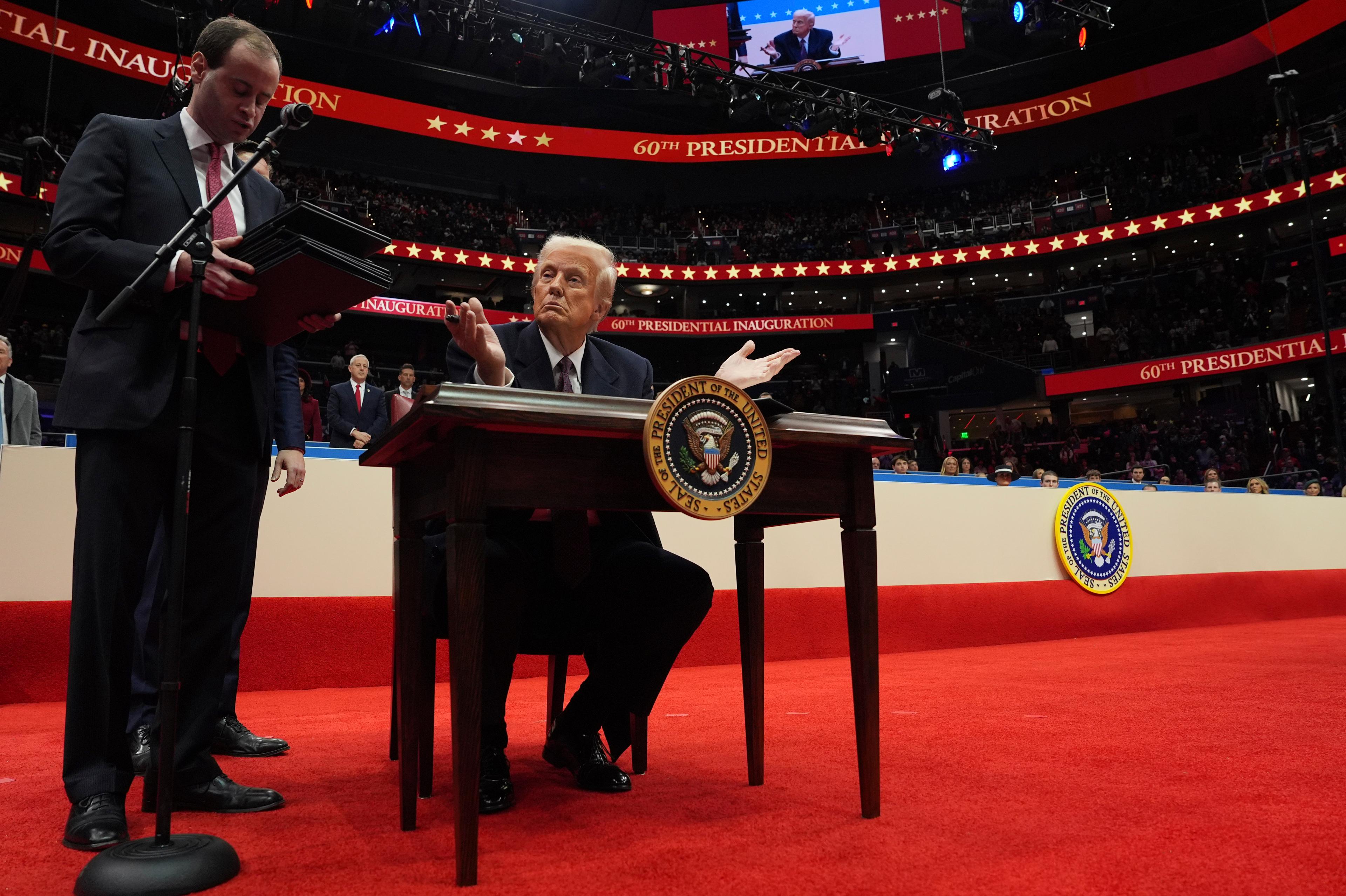 Trump at a table signing executive orders