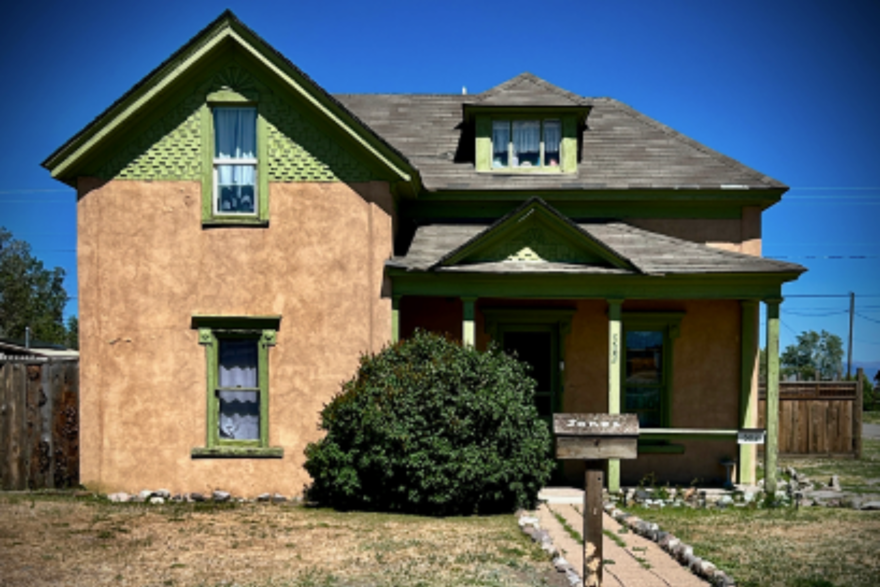 Photo shows a stucco house with Victorian styling built in 1888 in Antonito, CO.