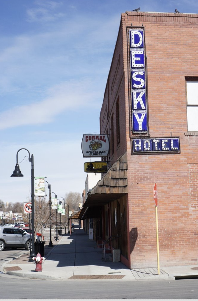 The side of the Knearl Block and Opera House building in Brush, CO. with street lamps and a sidewalk in front.