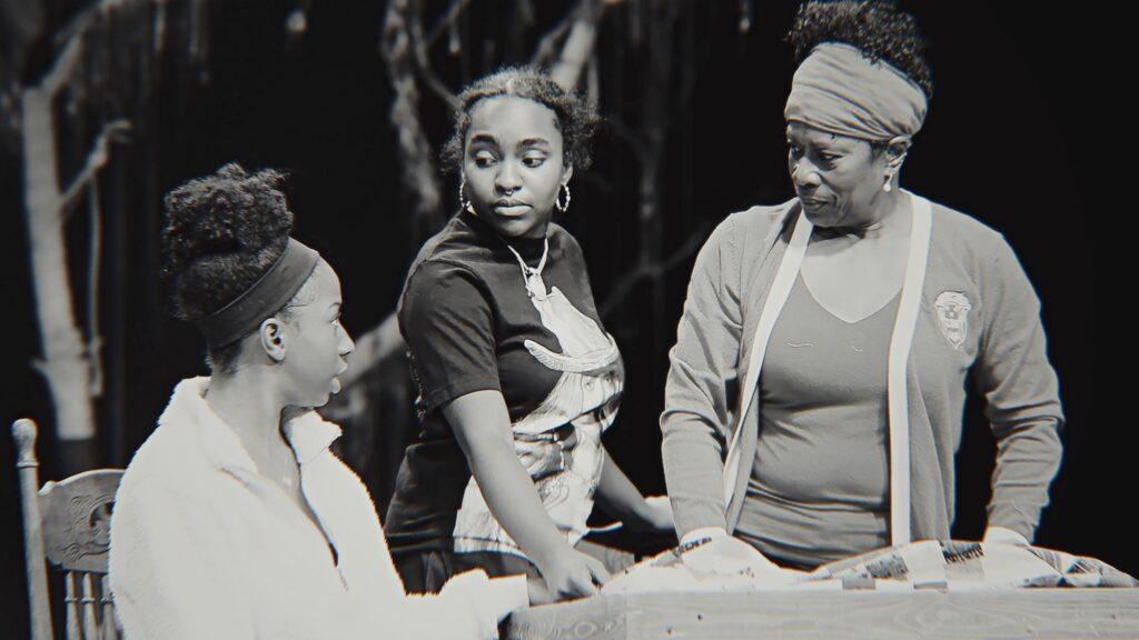 In a scene from Gee’s Bend at the Aurora Fox, three women gather around a table.