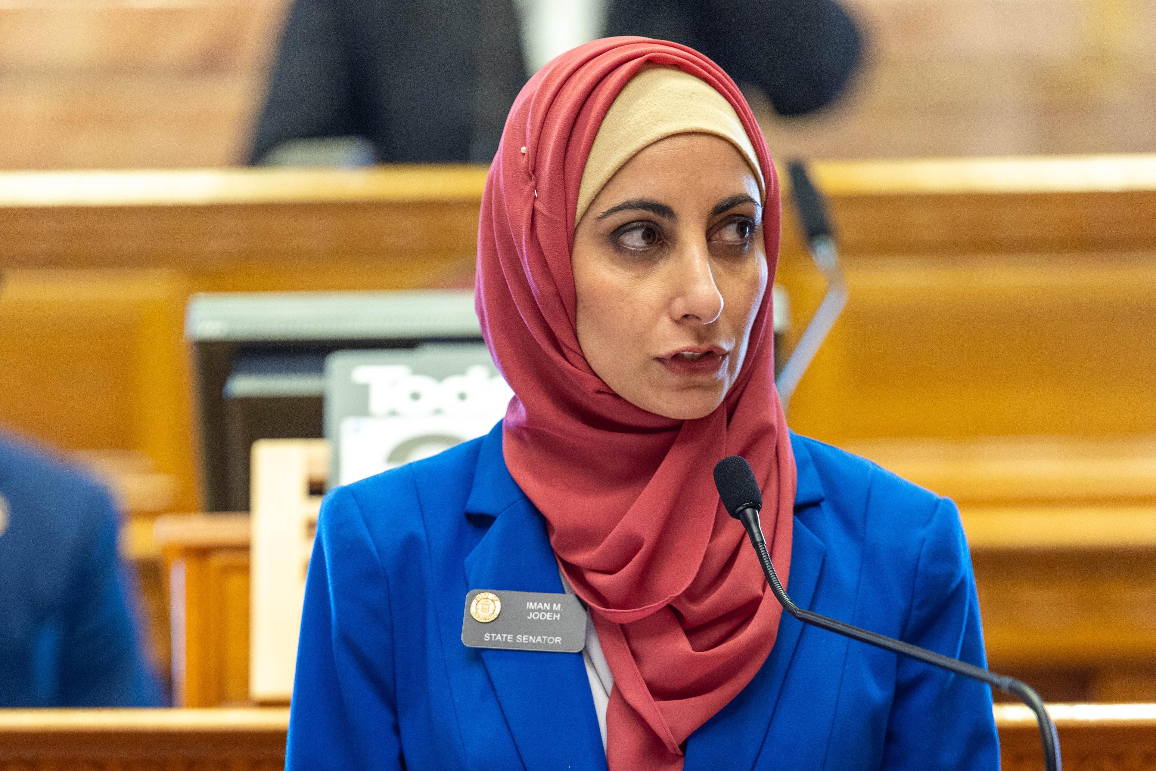 woman wearing hijab standing up wearing blue suit