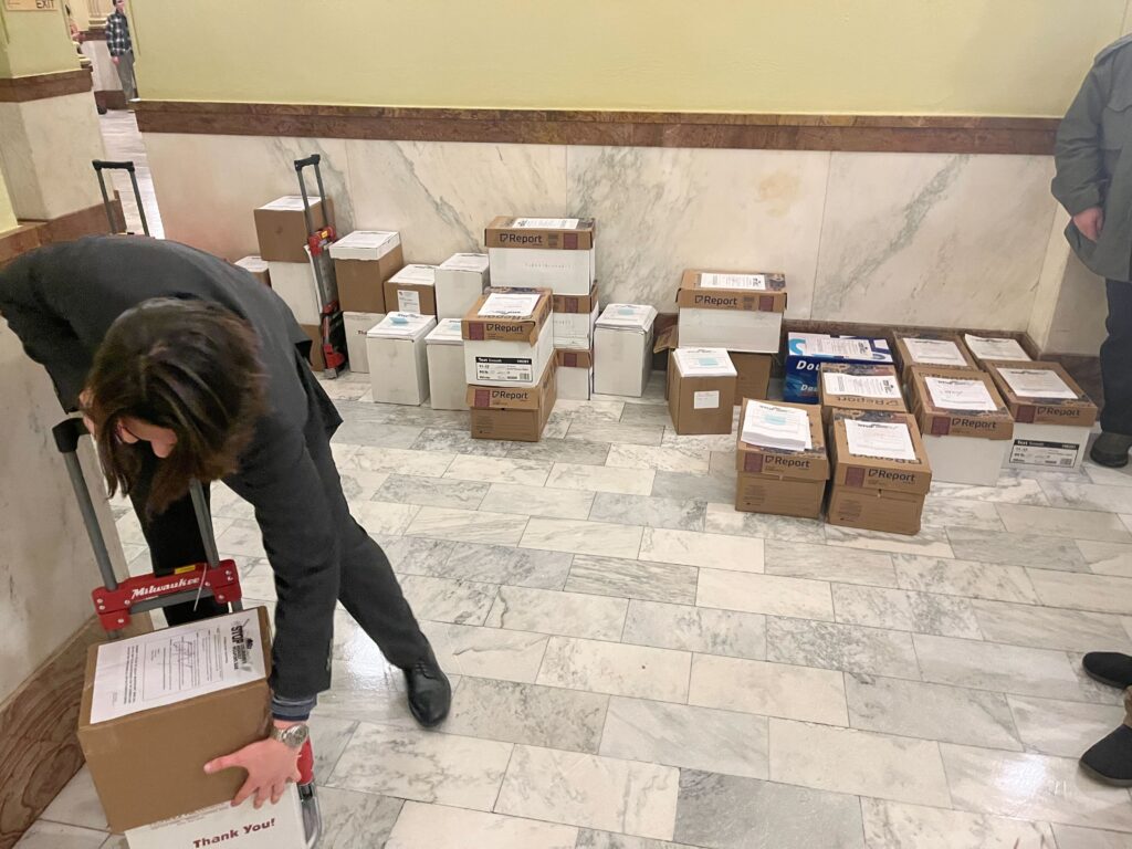 Stacks of cardboard boxes in a marble lined hallway