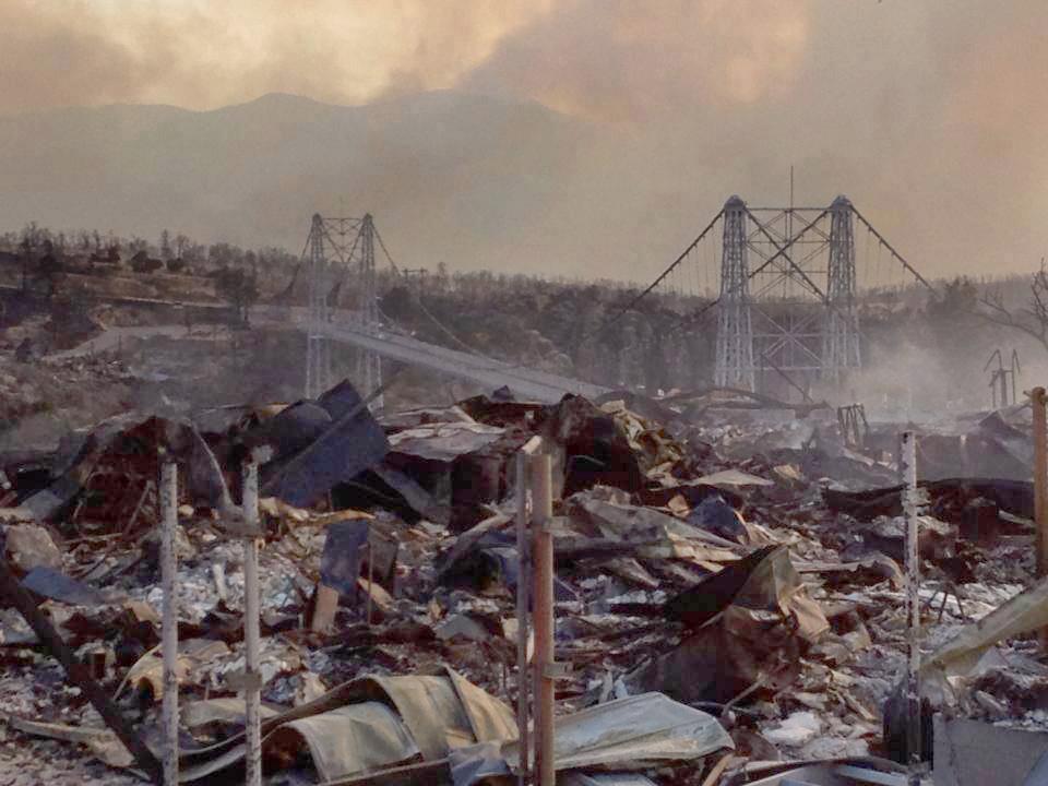 twisted burned metal with bridge in background