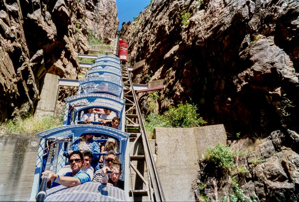 people in the metal cars of an incline ride