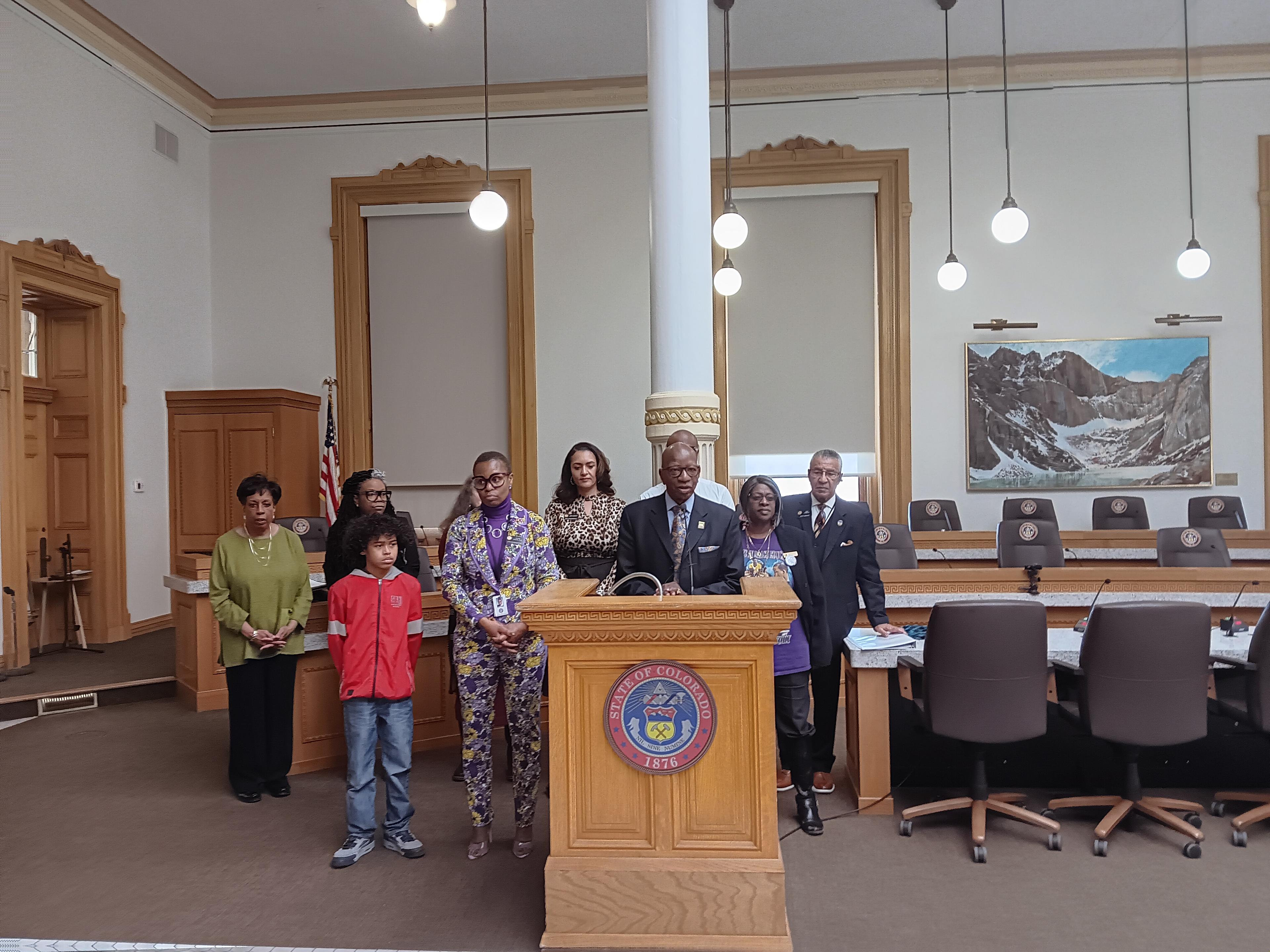 A group of people stand behind a podium