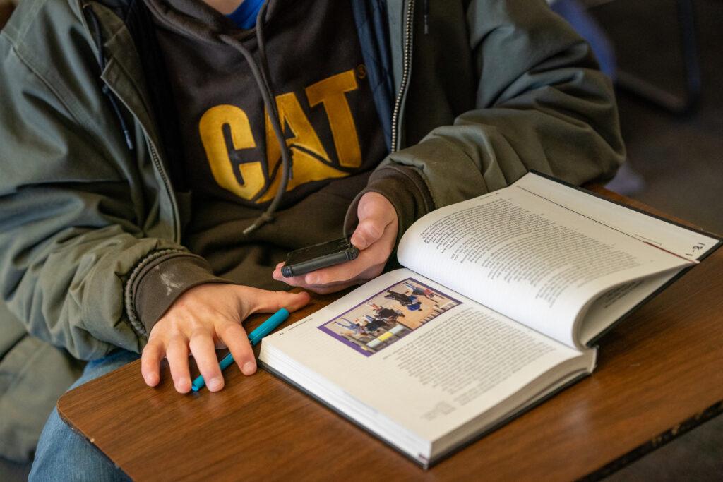 A student uses a phone while studying.