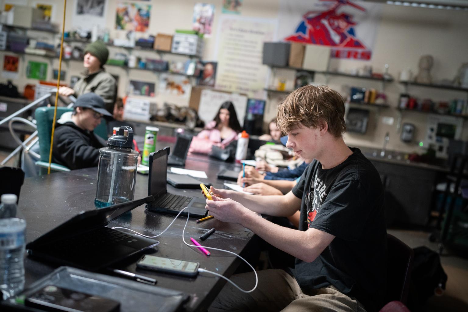 A student looks at a cell phone.