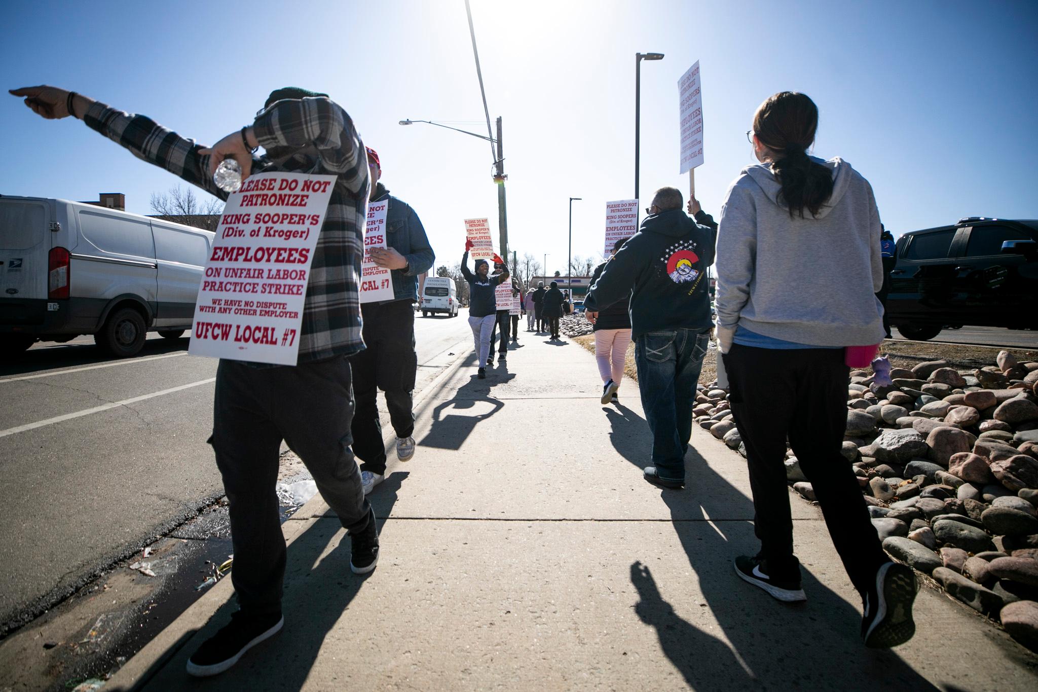 Picketers march in front of an east Denver King Soopers