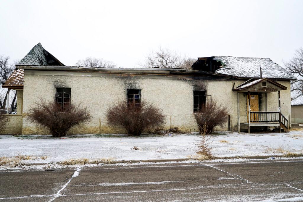 A burned-out building sits across from a city recreation center.