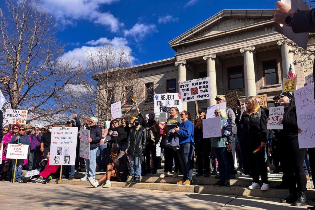 People holding signs gather outside