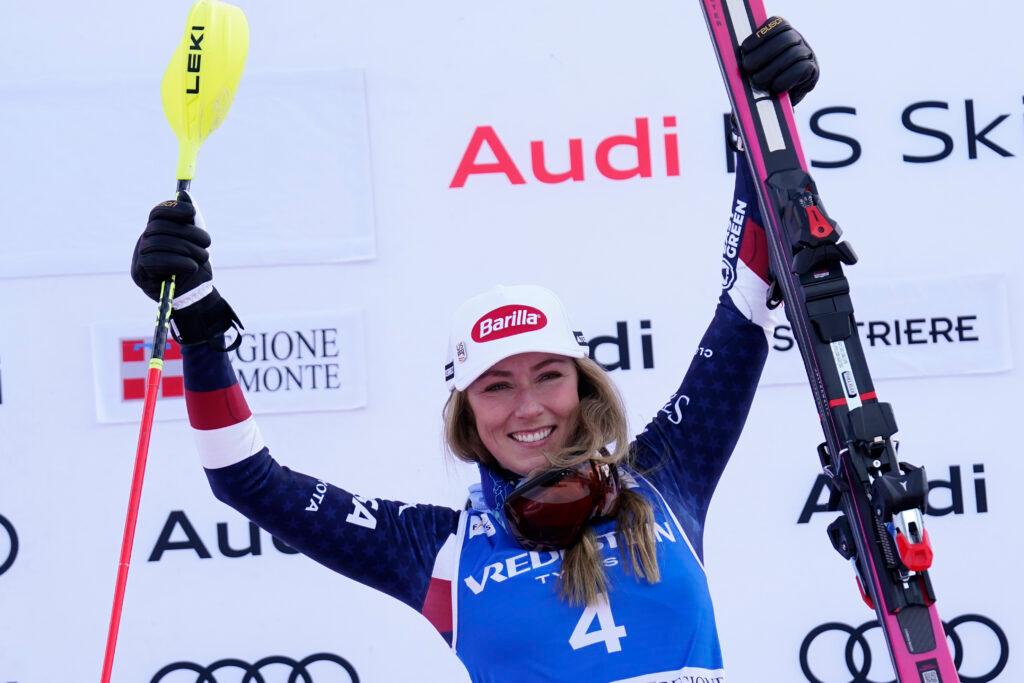 Mikaela Shiffrin raises her skis to celebrate her 100th World Cup slalom win.