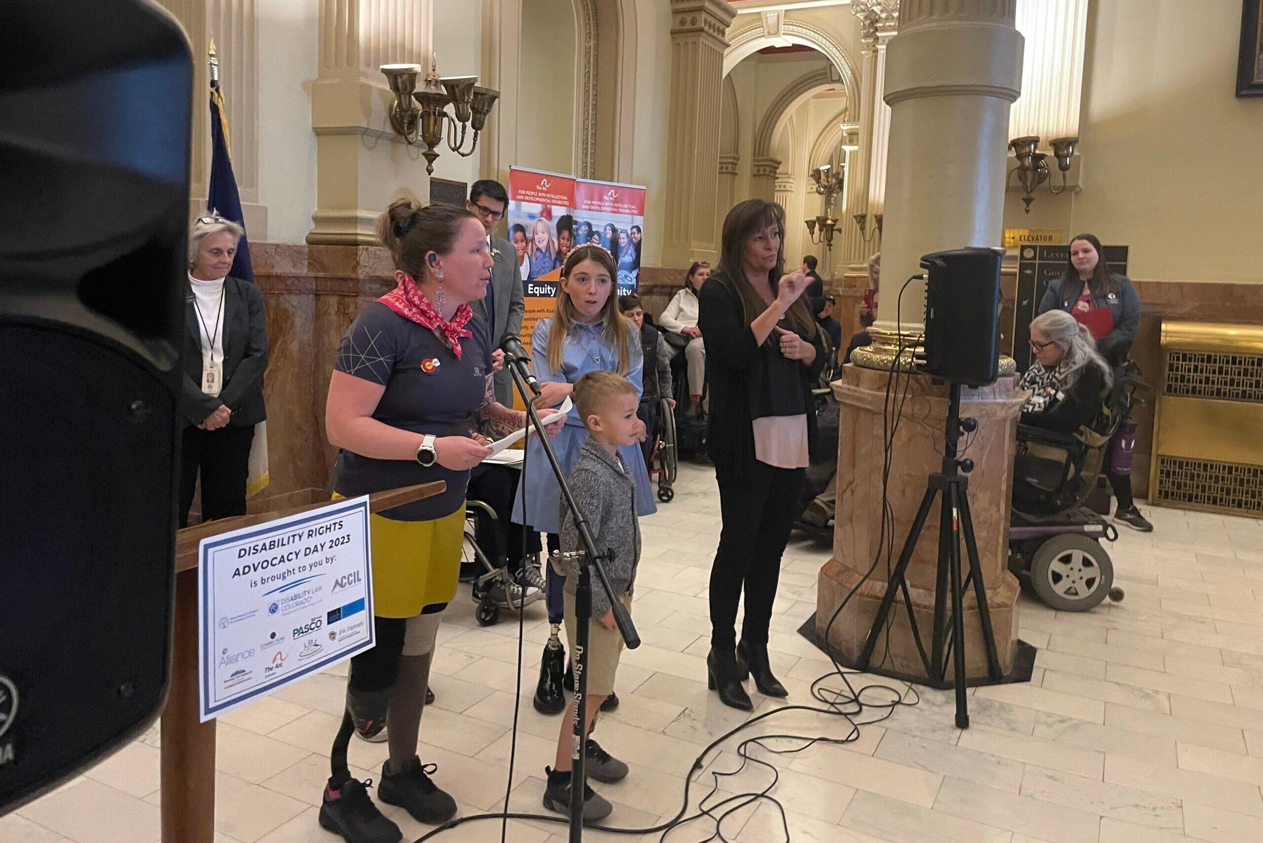 A group of disability advocates speak at the state capitol.