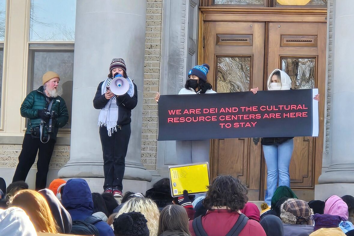 A large crowd of students at CSU gather to protest in front of an administration building.