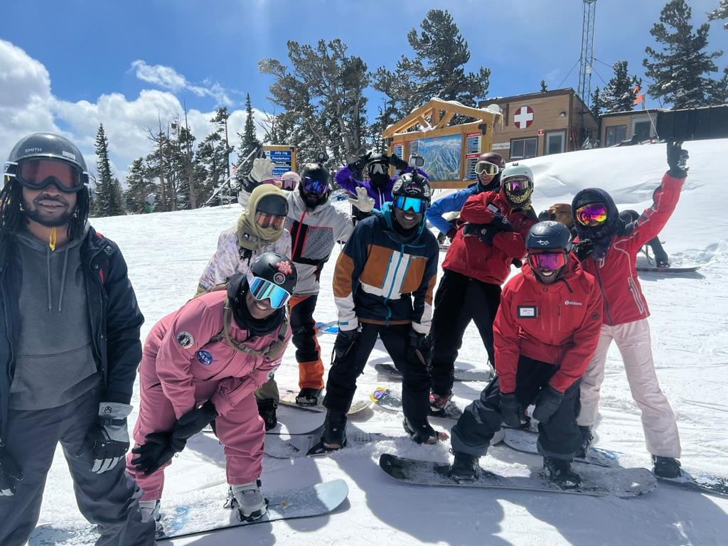 A group of skiers pose for a photo on a snowy slope.