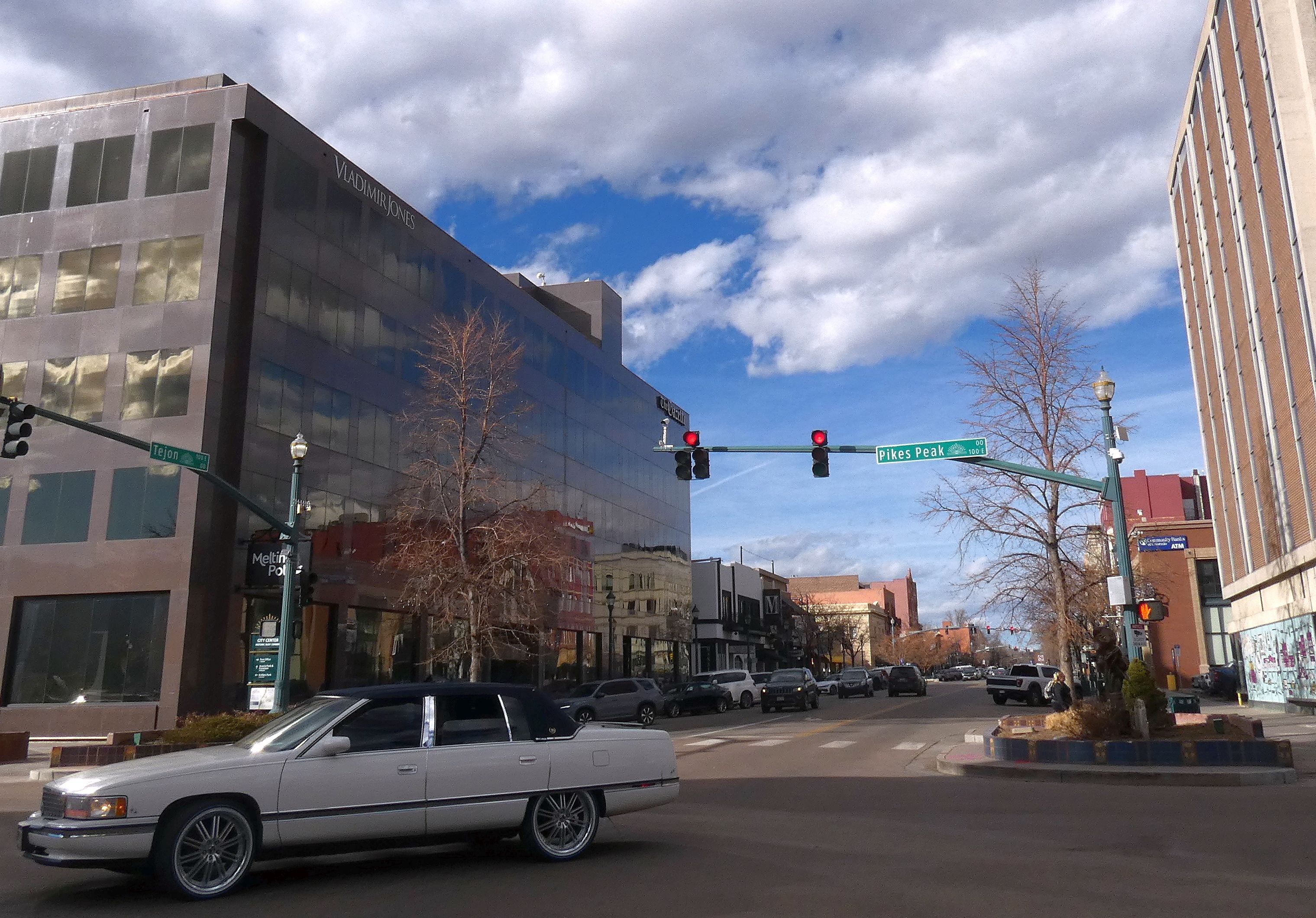 A white Cadillac turns from Pikes Peak Avenue to South Tejon Street in downtown Colorado Springs.