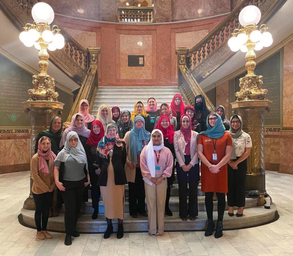 women standing on stairs of state capitol building wearing hijabs