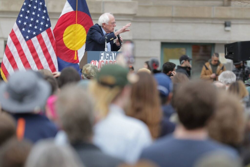 Bernie Sanders speaks at a podium reading &quot;Fight Oligarchy.&quot;