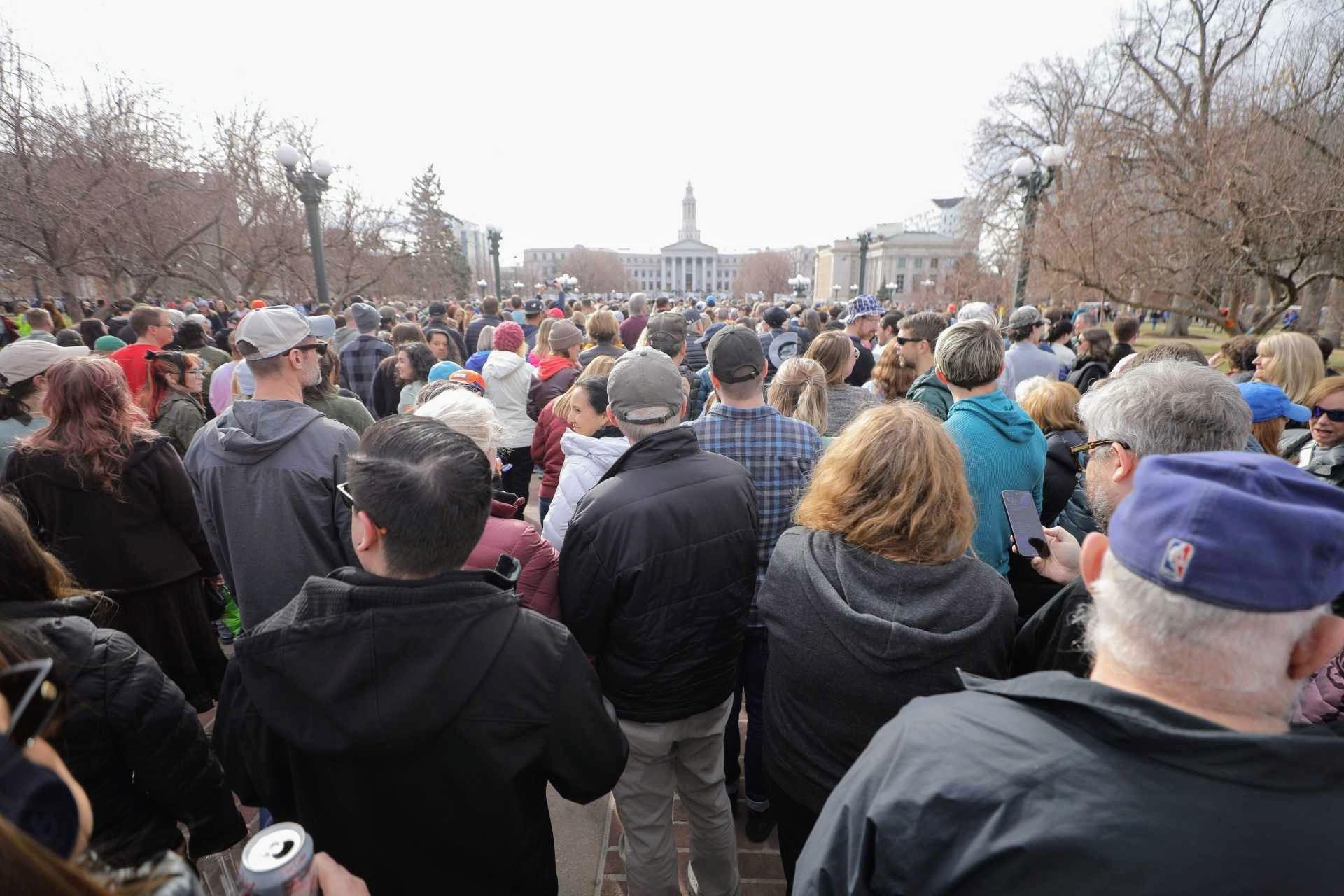 A sea of thousands of people in Civic Center Park. The City and County Building is in the background.