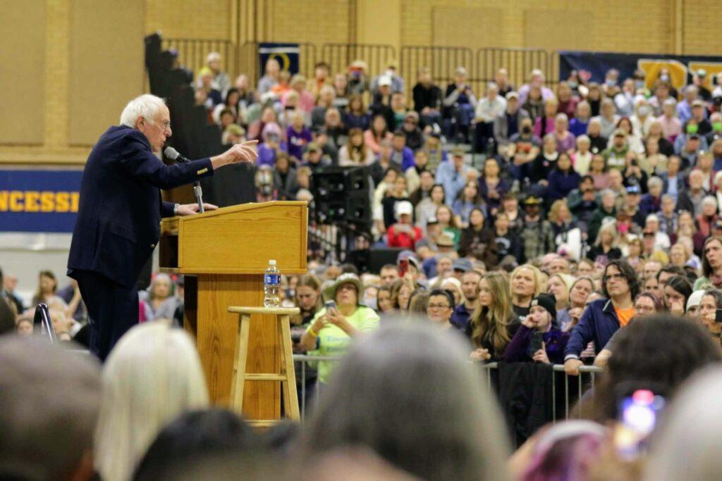 Bernie Sanders speaks from a podium at the Bank of Colorado , surrounded by a large crowdArena in Greeley