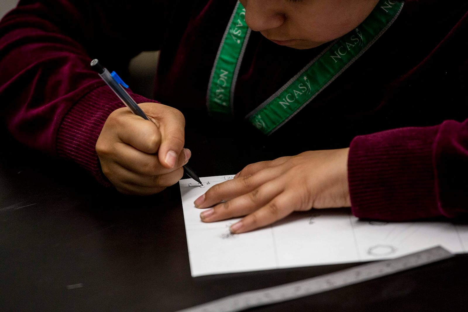 Student at desk writing in notebook