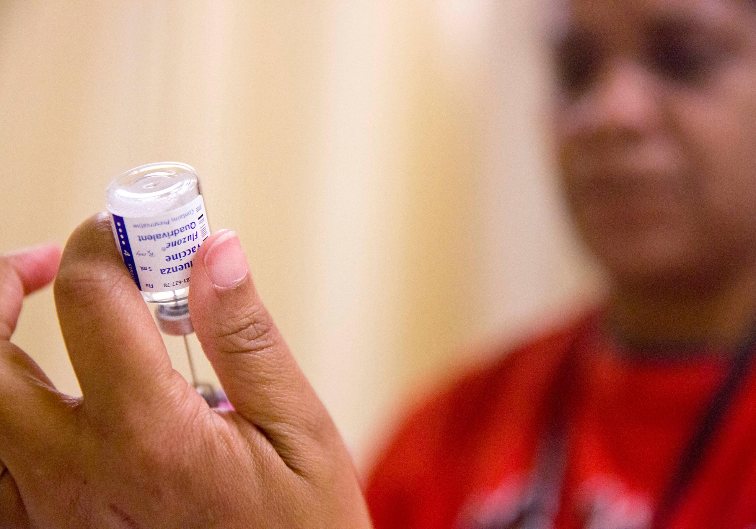 A nurse prepares a dose of the flu vaccine.