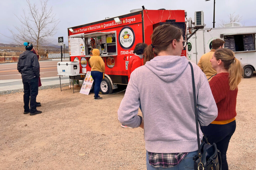 People standing around food trucks