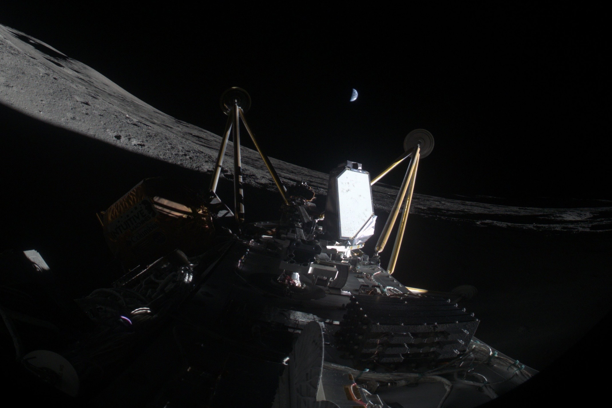 An on-board camera on a lunar lander shows the lander resting on its side on the Moon. Earth is seen in the background.