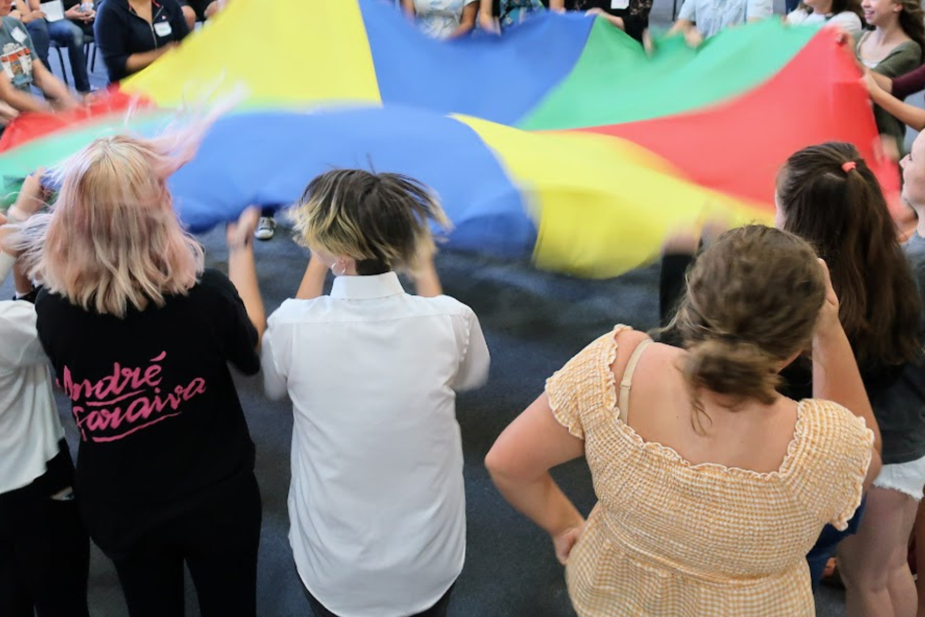 High school students lift up a parachute