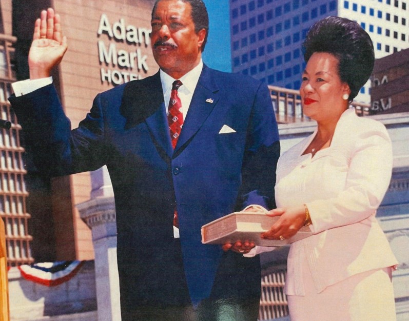 Wellington Webb is pictures with his right hand raised and his left hand on a Bible standing next to Wilma Webb who is also holding the Bible at the swearing-in ceremony for Denver mayor in 1991.