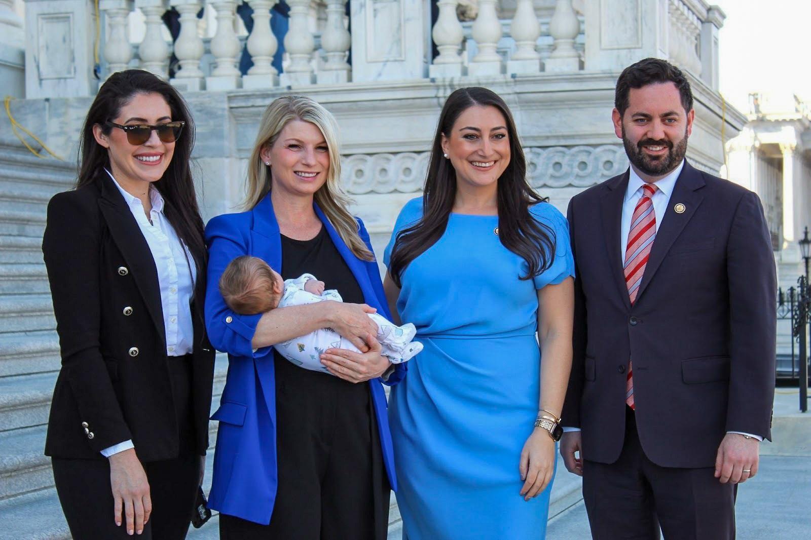 Four U.S. Representatives, Anna Paulina Luna, Brittany Pettersen, Sara Jacobs and Mike Lawler, stand together outside the U.S. Capitol. Pettersen holds her six-week-old son, Sam, in her arms.